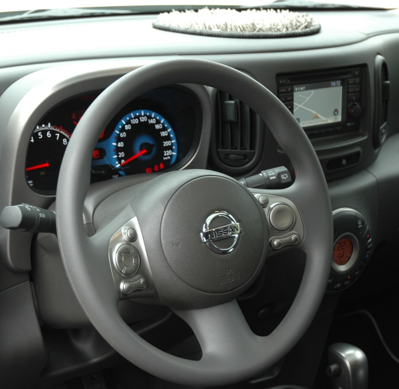 Blicks ins Nissan-Cube-Cockpit mit Fluffy-Matte auf dem Armaturenträger.