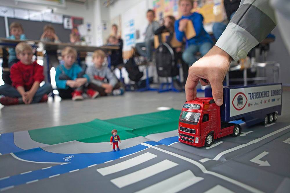 Theorieunterricht. Kindern einer dritten Klasse wird gezeigt, wie sie sich gegenüber Lkws im Verkehr verhalten sollen.