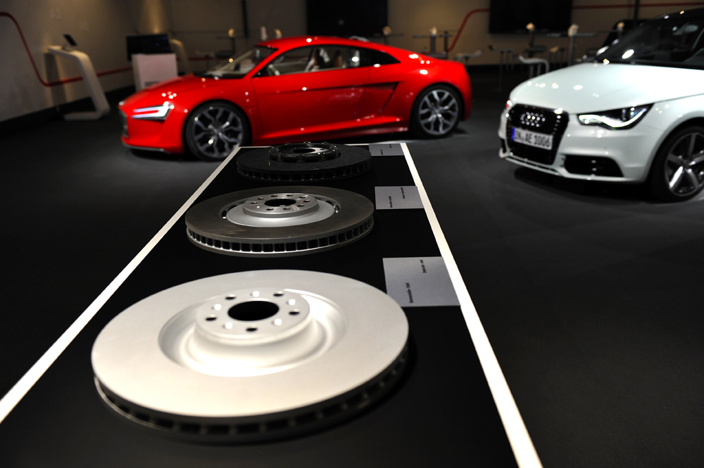 Blick auf Exponate bei der Präsentation, vorn Bremsscheiben, hinten e-tron-Modelle. 