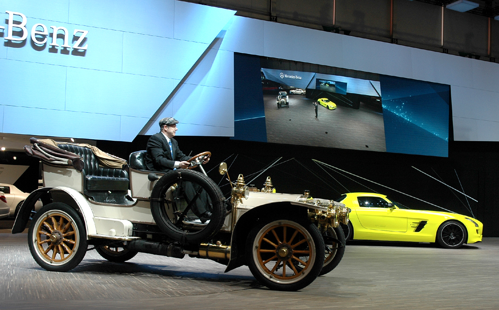Mercedes in Genf: Der Simplex-Oldtimer fährt am Elektro-SLS-AMG vorbei. 