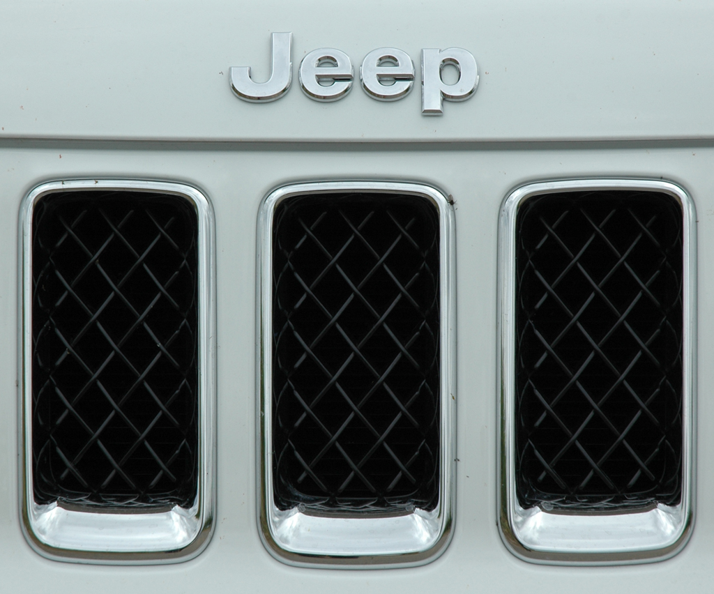 Jeep Compass: Kühlergrill-Ausschnitt mit Markenname vorn auf der Motorhaube. 