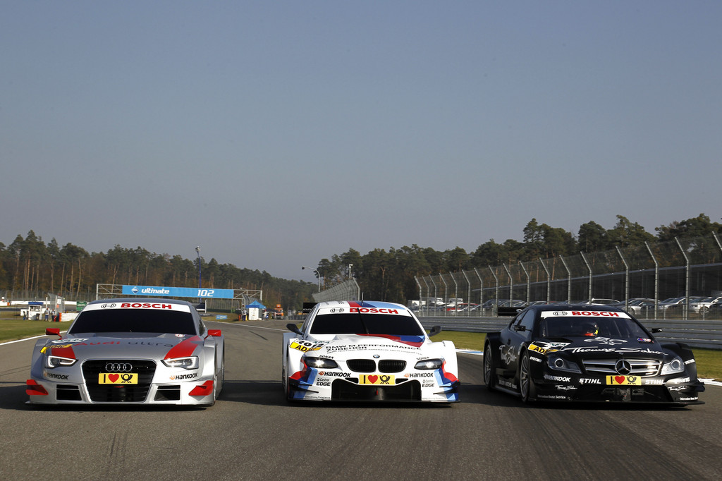 BMW M3 DTM umrahmt von den 2012-er Modellen von Audi und Mercedes-AMG.