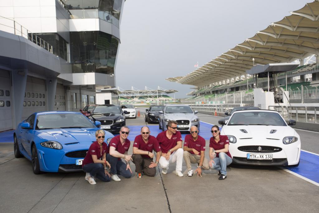Die glücklichen Gewinner, unter ihnen Detlef Schulz (dritter von links),  mit dem Jaguar XKR-S Coupe auf der Formel1-Strecke von