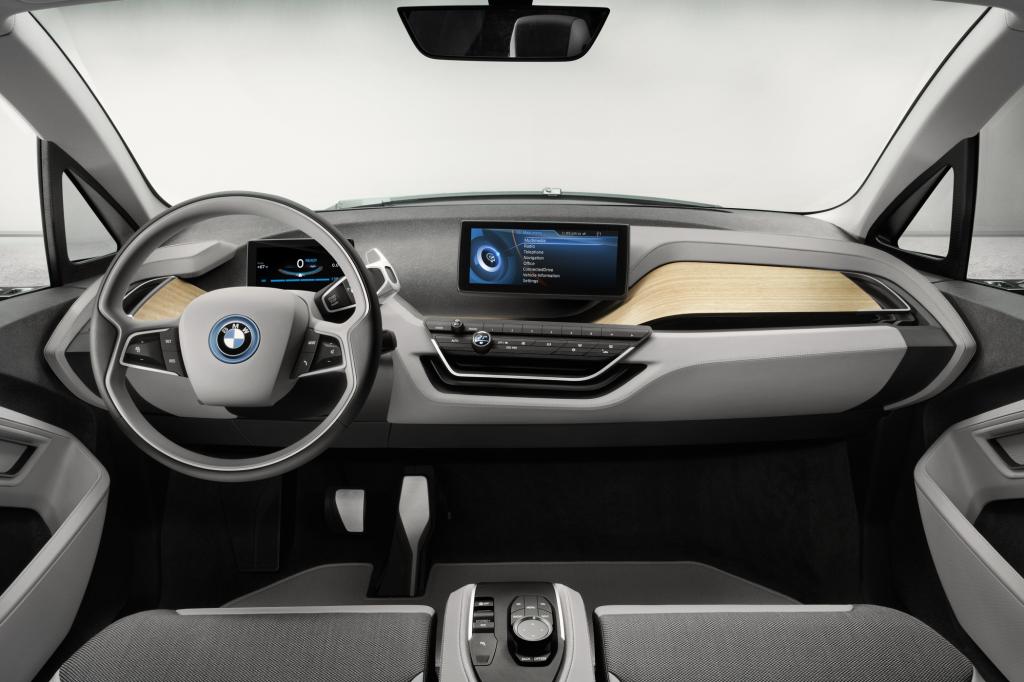 Auch innen hat der neue i3 große Ähnlichkeit mit dem Coupé-Konzept, Zwei Bildschirme, einer direkt vor dem Fahrer und einer in der Mitte, informieren den Fahrer, offenporiges Holz auf den Oberflächen schmeichelt der Hand