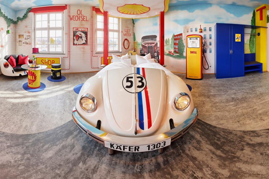Die Tankstellen-Suite mit Herbie-Bett, Zapfsäulen und Neon-Licht.