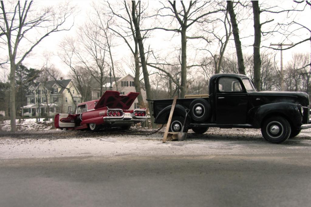 Ein schwarzer Pick-up zieht einen pinken Ford Thunderbird aus dem verschneiten Straßengraben - der Schnee ist übrigens Back-Natron