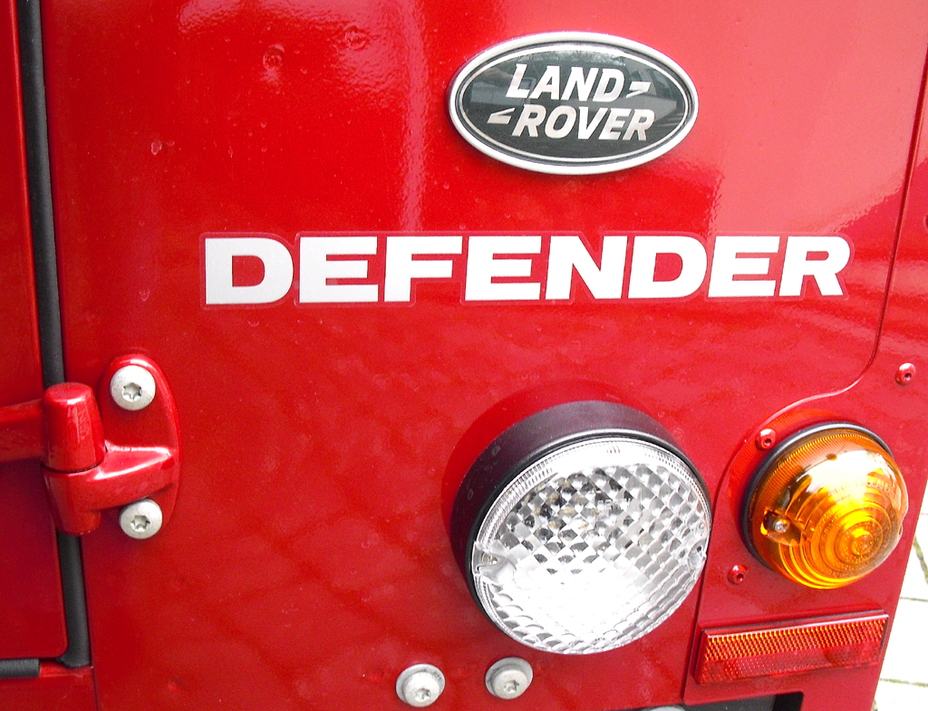 Land Rover Defender: Markenlogo, Modellschriftzug und Leuchteinheit am Heck. 