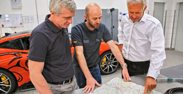 Mark Stanton, Chef-Ingenieur der Special Vehicle Operations von Jaguar Land Rover, und Phil Talboys, Leiter des Jaguar-Land-Rover-Testcenters am Nürburgring, sowie Christian Danner, Chefinstruktor der Jaguar Driving Academy, schauen sich die Strecke des Jaguar F-Type SVR Ring-Cat auf der Karte an.. Mark Stanton, Chef-Ingenieur der Special Vehicle Operations von Jaguar Land Rover, und Phil Talboys, Leiter des Jaguar-Land-Rover-Testcenters am Nürburgring, sowie Christian Danner, Chefinstruktor der Jaguar Driving Academy, schauen sich die Strecke des Jaguar F-Type SVR Ring-Cat auf der Karte an