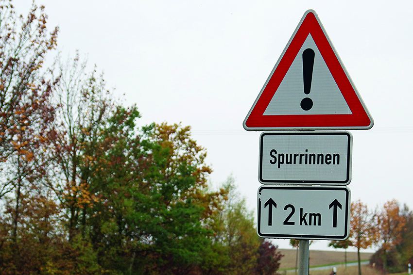 Hier deuten die Entfernungsangabe mit Pfeilen darauf hin, dass die Gefahr von Spurrinnen auf den folgenden zwei Kilometern besteht.